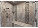 Stunning walk-in shower with dual shower heads, a built-in bench, and beautiful tile work at 17 Grand Corniche Dr, Henderson, NV 89011