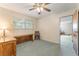 This carpeted bedroom is staged as a home office and features a vintage desk, chair, and window at 1904 Fontenelle St, Las Vegas, NV 89102
