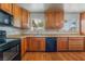 Well-lit kitchen with oak cabinets, black appliances, and light-colored laminate countertops at 1904 Fontenelle St, Las Vegas, NV 89102