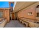 Charming exterior hallway featuring stone benches, a decorative urn, and a beautifully stained wooden door at 20 Via Mantova # 306, Henderson, NV 89011