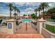 Outdoor community pool surrounded by palm trees, lounge chairs, and a beautiful view of the lake at 20 Via Mantova # 306, Henderson, NV 89011