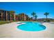 Inviting community pool with ample deck space, palm trees and desert views under a bright sky at 20 Via Mantova # 306, Henderson, NV 89011