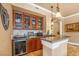 Chic wet bar area with custom cabinets, a wine refrigerator, and a granite countertop, perfect for entertaining at 20 Via Mantova # 306, Henderson, NV 89011