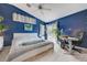 Cozy bedroom features bright blue walls, a ceiling fan, desk, and sliding doors to the outside at 224 Silver Castle St, Las Vegas, NV 89144