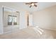 Bright bedroom featuring neutral carpet, ceiling fan, and mirrored closet doors at 2500 S Zephyr Ave, Pahrump, NV 89048