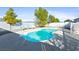A fenced backyard pool is nestled amongst trees, with multiple seating options at 2500 S Zephyr Ave, Pahrump, NV 89048