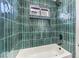Elegant bathroom shower with green tiling, built-in shelving, and tub at 2536 Herrod Dr, North Las Vegas, NV 89030