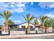 Single-story home with palm trees, white fence, carport, and fresh exterior paint at 2536 Herrod Dr, North Las Vegas, NV 89030