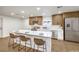 Modern kitchen featuring an island with seating, stainless steel appliances, and wooden cabinets at 2536 Herrod Dr, North Las Vegas, NV 89030