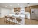 Bright kitchen with stainless steel appliances, wood cabinets, white countertops, and a kitchen island with seating at 2536 Herrod Dr, North Las Vegas, NV 89030
