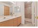 Bathroom featuring double sinks, a large vanity, and a walk-in shower at 272 Violet Note St, Henderson, NV 89074