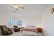 Large bedroom with a ceiling fan, dual windows, and a comfortable sitting area at 272 Violet Note St, Henderson, NV 89074