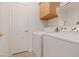 Functional laundry room equipped with a washer, dryer, and storage cabinet at 272 Violet Note St, Henderson, NV 89074