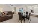 Open-concept living room with leather sofa, dining area, and staircase creating a welcoming atmosphere at 272 Violet Note St, Henderson, NV 89074