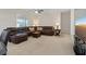 Spacious living room featuring a plush brown leather sectional and large window at 272 Violet Note St, Henderson, NV 89074