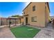 This backyard features a gravel and stone patio with a small patch of synthetic grass and a black gazebo at 2796 Sipe Springs St, Las Vegas, NV 89142