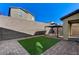 This backyard features a block wall and a gravel and stone patio with synthetic grass and a black gazebo at 2796 Sipe Springs St, Las Vegas, NV 89142