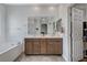 Bright bathroom featuring a double sink vanity, large mirror, soaking tub, and tiled floors at 2796 Sipe Springs St, Las Vegas, NV 89142