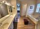 Bathroom featuring dual sinks, soaking tub and separate shower, plus ceramic wood-look flooring at 2809 Winslow Springs Dr, Henderson, NV 89052