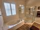 Bright bathroom featuring a soaking tub and glass-enclosed shower with wood look tile flooring at 2809 Winslow Springs Dr, Henderson, NV 89052
