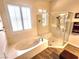 Bright bathroom featuring a soaking tub and glass shower with wood-look tile flooring at 2809 Winslow Springs Dr, Henderson, NV 89052