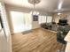 Open dining area with wood-look tile flooring and an ornate chandelier, flowing into the living room at 2809 Winslow Springs Dr, Henderson, NV 89052