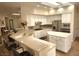 Well-lit kitchen featuring white cabinets, stainless steel appliances, tiled backsplash, large island, and breakfast bar seating at 2809 Winslow Springs Dr, Henderson, NV 89052