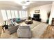Bright living room featuring neutral tones, carpet, large windows with shutters, and a comfortable gray sofa at 2809 Winslow Springs Dr, Henderson, NV 89052