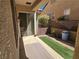 Cozy covered patio featuring a sliding glass door, rock landscaping, and artificial turf at 2809 Winslow Springs Dr, Henderson, NV 89052