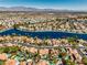 Expansive aerial view of a community, showcasing homes near a lake, lush greenery, and scenic surroundings at 2909 Sterling Cove Dr, Las Vegas, NV 89128