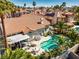 Lush backyard with a sparkling pool, outdoor dining, and comfortable seating under a pergola, perfect for entertaining at 2909 Sterling Cove Dr, Las Vegas, NV 89128