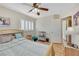 Cozy bedroom featuring a ceiling fan, wood-look floors, and window shutters for natural light control at 2909 Sterling Cove Dr, Las Vegas, NV 89128