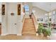 Inviting entryway with wooden staircase and abundant natural light from the large arched window above at 2909 Sterling Cove Dr, Las Vegas, NV 89128
