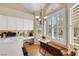 Eat-in kitchen with built-in bench seating, white cabinetry, and views of the pool through shuttered windows at 2909 Sterling Cove Dr, Las Vegas, NV 89128