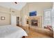 Bedroom featuring fireplace, wood floors, and an ensuite bathroom with a luxurious design and abundant natural light at 2909 Sterling Cove Dr, Las Vegas, NV 89128