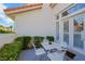 Cozy outdoor patio with seating, lush greenery, and a view of the home's exterior at 2909 Sterling Cove Dr, Las Vegas, NV 89128