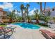 Backyard pool surrounded by tropical palm trees, lounge chairs, and concrete patio at 2909 Sterling Cove Dr, Las Vegas, NV 89128