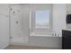 Bright bathroom features a glass enclosed shower and a soaking tub with a window view at 2951 Overlook Brook St, Las Vegas, NV 89156