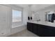 Bright bathroom featuring a soaking tub, glass enclosed shower, and a double sink vanity at 2951 Overlook Brook St, Las Vegas, NV 89156