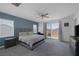 Bedroom with gray walls, large windows, a ceiling fan, and access to the balcony at 2951 Overlook Brook St, Las Vegas, NV 89156