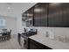 Modern kitchen features dark cabinets, stainless steel appliances and light stone countertops at 2951 Overlook Brook St, Las Vegas, NV 89156