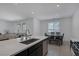 The modern kitchen features a light stone island with a dining area leading to the living room at 2951 Overlook Brook St, Las Vegas, NV 89156