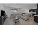 Bright, open-plan living room with tile flooring, a large sectional, and easy access to the kitchen at 2951 Overlook Brook St, Las Vegas, NV 89156
