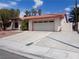 Traditional style home with tile roof, desert landscaping and wide driveway leading to an attached two car garage at 3024 Nutwood St, Las Vegas, NV 89108