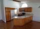 Well-lit kitchen with wood cabinets, stone countertops, a sink, and modern appliances at 3024 Nutwood St, Las Vegas, NV 89108