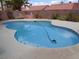 Relaxing kidney-shaped pool with surrounding concrete patio, perfect for outdoor entertaining and backyard enjoyment at 3024 Nutwood St, Las Vegas, NV 89108