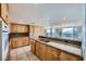 Bright kitchen with wood cabinets, tile floor, granite countertops, and large windows at 3111 Bel Air Dr # 18B, Las Vegas, NV 89109