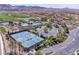 This aerial shows tennis courts, a pool and clubhouse surrounded by desert landscaping with mountain views at 32 Cerchio Basso, Henderson, NV 89011