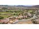 Aerial view of a desert community showing homes, landscaping, a golf course, mountains, and a location pin on a home at 32 Cerchio Basso, Henderson, NV 89011