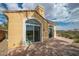 A home's back patio features a stucco wall, sliding doors, and a concrete patio with views of the Nevada landscape at 32 Cerchio Basso, Henderson, NV 89011